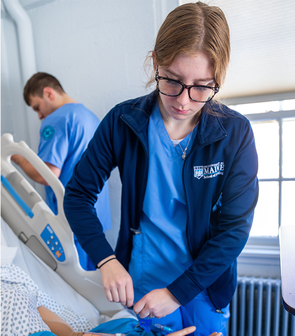 A photo of a nursing student working on a dummy. 
