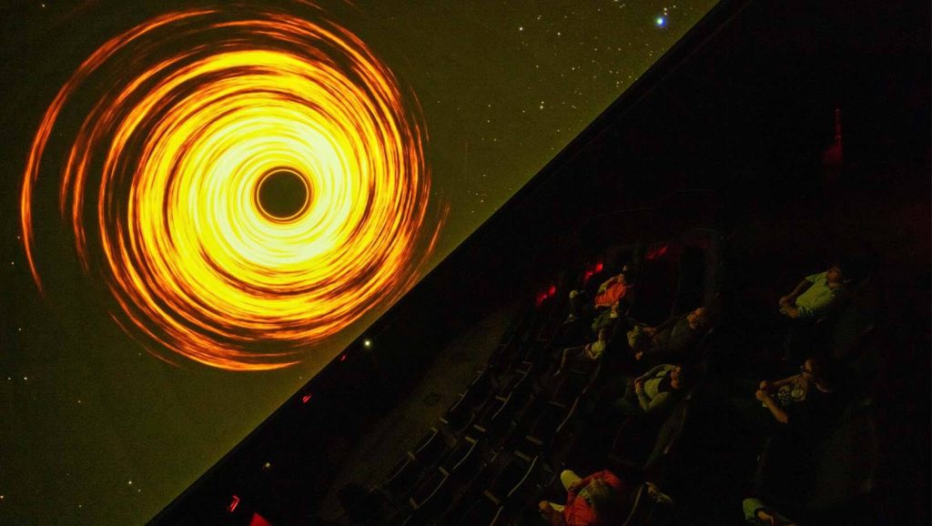 A photo of people viewing a show at the Astronomy Center