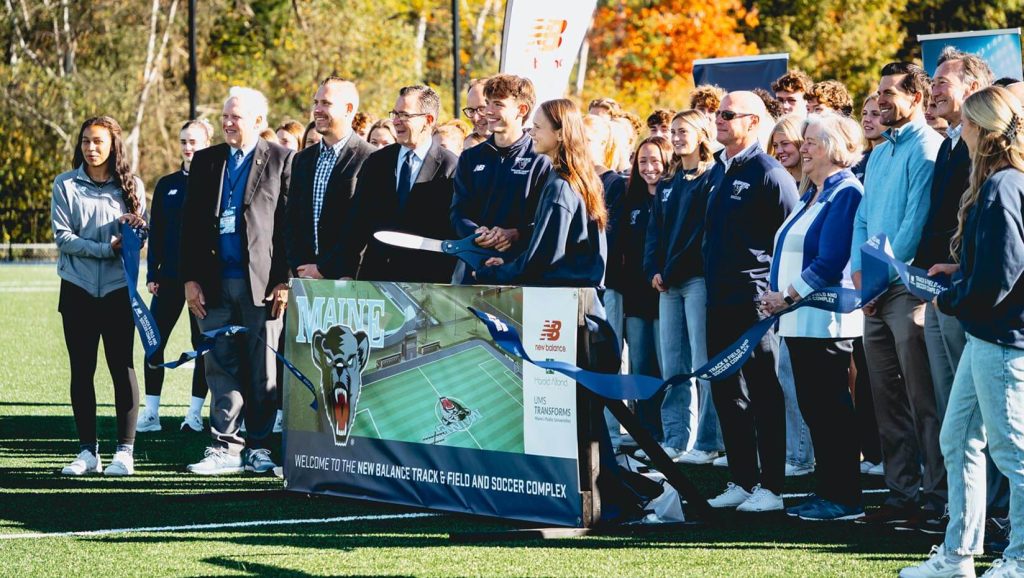A photo of people gathered at the UMaine Track & Field Complex ribbon cutting